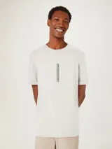 Remera beige de corte recto con estampa vertical en el centro del pecho.