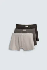 Pack de tres calzoncillos tipo bóxer de tejido elástico con acabado aterciopelado y cintura elástica. Incluye un bóxer color gris claro, uno gris oscuro y uno marrón.