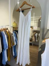 Vestido largo confeccionado en 100% lino de color naranja tierra, con escote en V y tirantes finos. Presenta un diseño fluido y minimalista ideal para la temporada de verano.