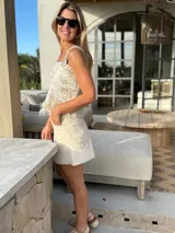 Top color crema con detalles dorados y breteles de cuero artesanales.