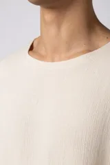 Remera negra de tejido tipo lino, corte holgado y cuello redondo. Sin estampas ni bordados.