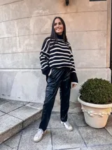 Sweater de punto grueso a rayas horizontales blancas y negras, con cuello alto y mangas largas.