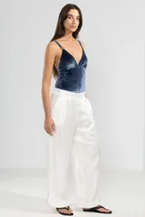 Pantalón blanco de lino italiano con hilo metalizado, corte recto, talle medio, cintura elástica en la parte trasera y bolsillos delanteros.