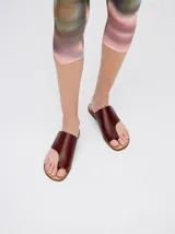 Sandalias de cuero color marrón con tira ancha sobre el empeine y abertura para el dedo gordo.