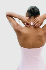 Vestido corto blanco de tejido de punto elástico, con cuello halter, escote corazón y cierre con botones en el cuello.