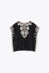 Top de Zara Woman Collection, color negro con apliques de crochet en color crudo. Cuello redondo y manga corta caída. Cierre en la espalda con abertura y botón.