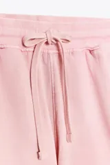 Shorts de tiro alto confeccionados en tejido con efecto lavado, cintura elástica ajustable con cordones, bolsillos laterales de vivo y tejido combinado en rib a tono.