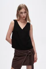 Blusa color beige de poliéster, al cuerpo y con cuello en V.