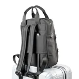 Mochila negra de cuero sintético con diseño acolchado vertical, doble asa de mano y correas regulables. Tiene dos bolsillos externos con cierre, un compartimento principal con cierre, un bolsillo interno con cierre y dos bolsillos internos abiertos.