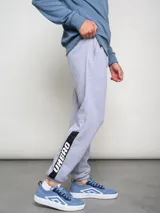 Pantalón de jogging negro con puños ajustados, cortes laterales y cambio de color en la parte inferior de la pierna.
