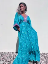 Vestido largo tipo túnica color turquesa con estampado de cachemir y detalles bordados en el escote y las mangas.