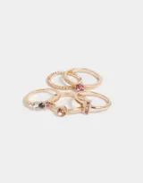 Set de cinco anillos dorados con detalles en relieve y strass multicolor.