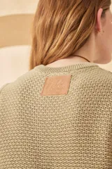 Chaleco de punto color verde oliva, sin mangas, con diseño calado y cuello redondo.