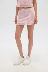 Minifalda de poliéster con estampado a cuadros rosas y blancos, con detalle de moño en la cintura.