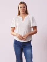 Remera blanca de poliéster, rayón y elastano, con cuello a la base y escote en V. Manga corta amplia bordada. Marca Cable & Gauge.