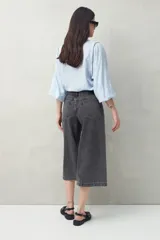 Pantalón culotte de denim color gris oscuro, tiro medio y silueta amplia, con largo por encima del tobillo.