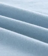 Musculosa masculina color celeste, de corte comfort, cuello redondo y sin mangas. Presenta un estampado localizado de palmera en el pecho.