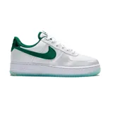 Championes urbanos Nike Air Force 1 '07 Essentials de mujer, color blanco con detalles en verde. Presentan el logo de Nike en verde en los laterales y la leyenda 'Air' en la entresuela.