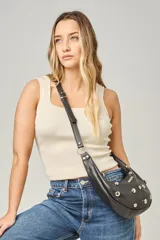 Bolso de hombro tipo media luna, color negro, con tachas metálicas redondas plateadas y correa ajustable con hebilla.