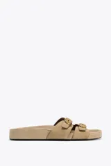 Sandalias planas color beige de serraje, con doble tira delantera con hebillas y punta redonda.
