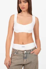 Conjunto de microshort y top blanco de tejido de punto. El top es un corpiño con aros en la copa y terminaciones envivadas. El short tiene elástico en la cintura.