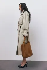 Cartera bombonera marrón de gamuza con correa ajustable y asa de hombro.