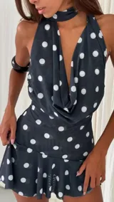 Minivestido negro con estampado de lunares blancos, escote drapeado y cuello halter.