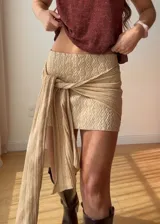Mini falda marrón elastizada con lazo. El tono del color puede variar por diferencias en la composición de los hilados.