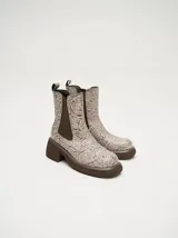 Botas Chelsea color beige con estampado floral, elástico lateral marrón y suela track color marrón.