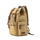 Mochila de tela canvas color verde oliva con tapa y detalles en símil cuero marrón. Cierre superior marinero, bolsillos internos, externos frontal, laterales y trasero con cierre. Asas rígidas, correas ajustables y espacio para laptop de 15".