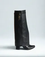 Bota Givenchy Shark Lock de cuero negro con caña alta y punta fina. Presenta un candado plateado con llave en el tobillo.