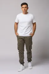 Pantalón cargo color beige de gabardina, con corte ajustado, bolsillos laterales con fuelle y puños elásticos en los tobillos.
