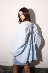 Camisa celeste super holgada con hombro caído y manga ancha. Tiene un volado en el cuello y efecto arrugado en la espalda.
