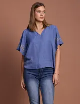 Blusa color beige de crepe marca Batía, con cuello a la base y escote en V. Presenta mangas cortas amplias con bordados.