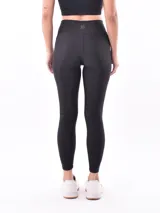 Calza deportiva negra de tiro alto, corte ajustado y largo completo.