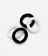 Set de cuatro gomitas de pelo gruesas, dos de color negro y dos de color blanco, con textura acanalada.