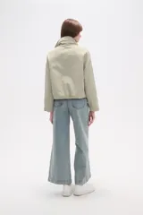 Campera de corte holgado en color tostado, confeccionada en poliamida. Presenta cuello alto, cierre frontal con cremallera, bolsillos laterales con cierre y cordón ajustable en el ruedo.