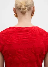 Camiseta roja con textura, cuello redondo y mangas cortas. Diseño entallado.