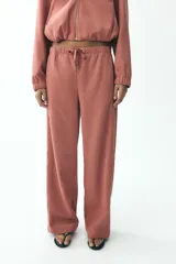 Pantalón de tiro alto color ladrillo, con cintura elástica ajustable, bolsillos delanteros y traseros. Corte ancho.