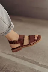 Sandalias de cuero marrón con tiras tejidas a mano y costuras a la vista.