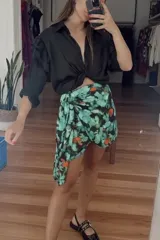 Minifalda asimétrica con estampado floral en tonos verde, negro y naranja.