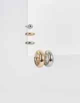 Set de cinco aros que incluye dos argollas gruesas, una dorada y otra plateada, un aro tipo cuff plateado con textura, un aro dorado liso y un aro plateado con forma de bolita.