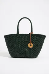 Bolso tipo tote tejido en color verde oscuro, con doble asa corta y dije circular de cuero con inscripciones.