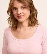 Pijama largo rosado de ribana con lunares, compuesto por una blusa de mangas largas y cuello redondo, y un pantalón largo con cintura elástica.