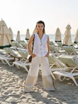 Pantalón ancho de corte recto, color blanco con bloques de color beige en la parte inferior de las piernas.