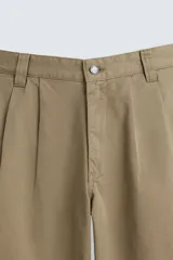 Pantalón color caqui de corte amplio, con pinzas en la cintura, bolsillos laterales y traseros con botón.