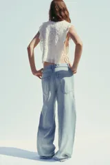Pantalón de jean celeste de tiro alto con cintura doblada, cinco bolsillos, efecto lavado y roturas.
