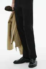 Pantalón negro de corte slim fit, confeccionado en sarga elástica de algodón. Cuenta con cierre y botón, bolsillos al bies y bolsillos insertados atrás con botón.