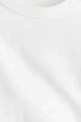 Remera blanca de corte cuadrado, con cuello redondo y mangas cortas.