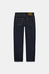 Jeans de tiro medio color beige, corte cigarette, con cinco bolsillos y cierre frontal de cremallera y botón.